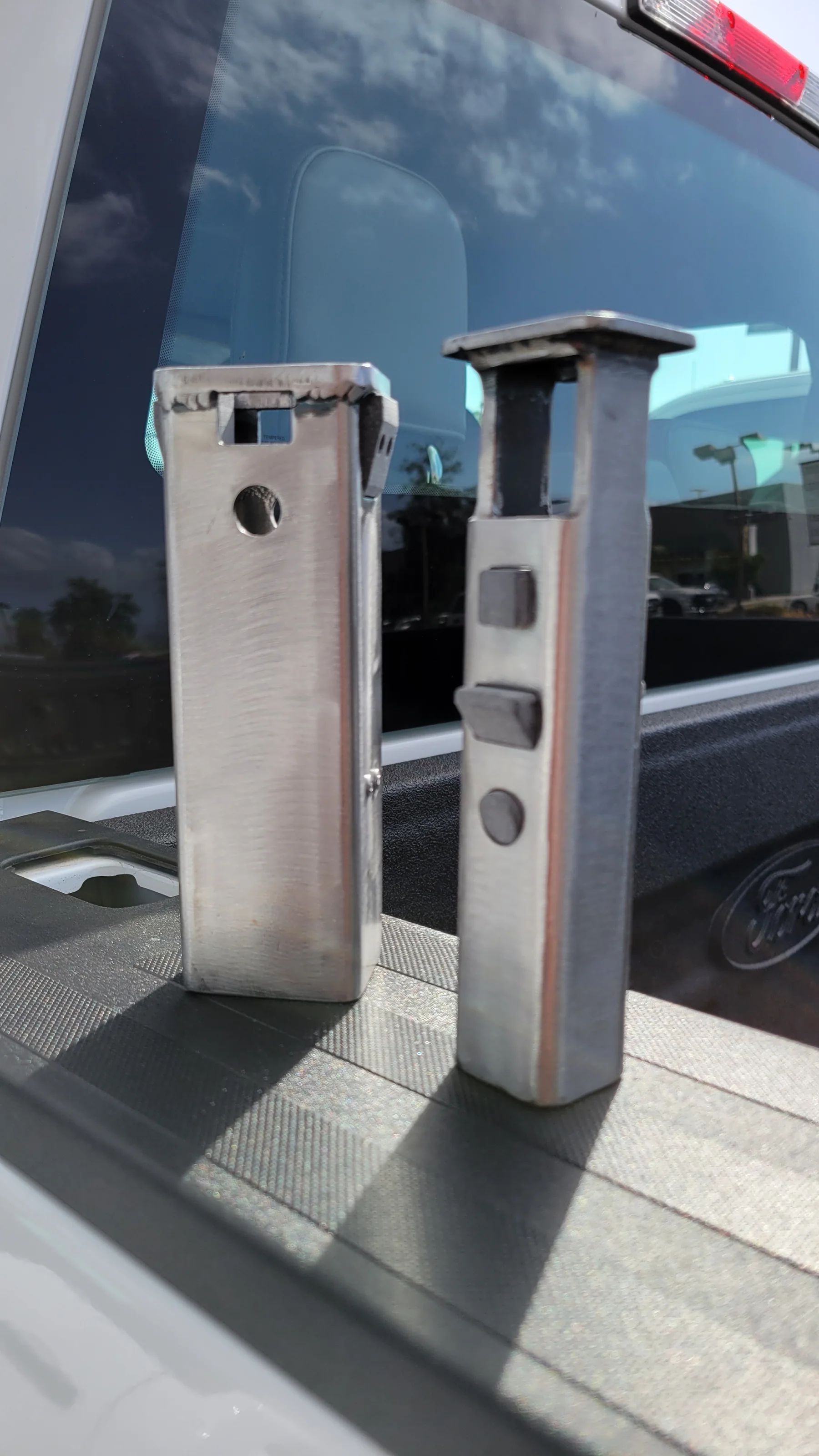 Two metal Pocket Anchor prototypes installed in a truck bed rail